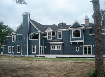 Custom home construction with dark gray siding and white trim